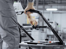 Load image into Gallery viewer, Close-up of a person holding the PUDU MT1 manual steering handle