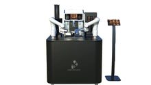 Load image into Gallery viewer, A Useabot Dual-Arm Robotic Coffee Station by Elite Robots (Open-Style Workbench) sits on a black counter beside a touchscreen ordering panel, offering self-service coffee against a plain white background.
